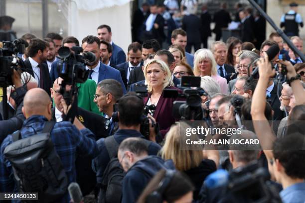 French far-right Rassemblement National leader and Member of Parliament Marine Le Pen is surrounded by journalists as she arrives at the French...