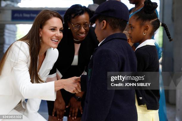 Britain's Catherine, Duchess of Cambridge, speaks to guests as she attends the unveiling of the National Windrush Monument at Waterloo Station in...