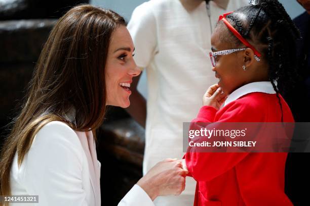 Britain's Catherine, Duchess of Cambridge, speaks to a girl as they attend the unveiling of the National Windrush Monument at Waterloo Station in...