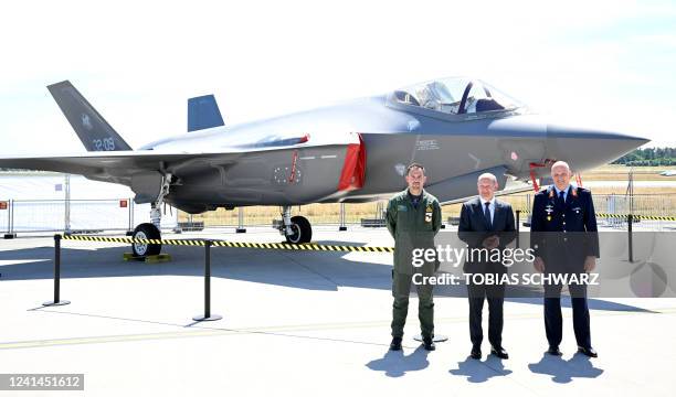 German Chancellor Olaf Scholz , Italian pilot Capitano Alberto Bosi and Lieutenant General of the German Air Force Ingo Gerhartz pose in front of a...