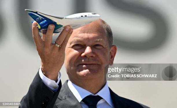 German Chancellor Olaf Scholz holds the model of an H2 powered Airbus ZEROe airplane as he officially opens the ILA Berlin Air Show in Schoenefeld...