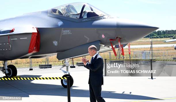 German Chancellor Olaf Scholz walks past a Lockheed Martin F-35 fighting jet during his tour to officially open the ILA Berlin Air Show in...