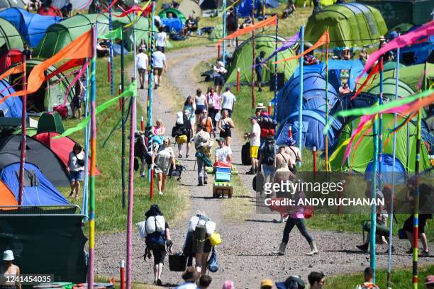 Festivalgoers arrive to attend the Glastonbury festival in the village of Pilton, in Somerset, South West England, on June 22, 2022. - More than...