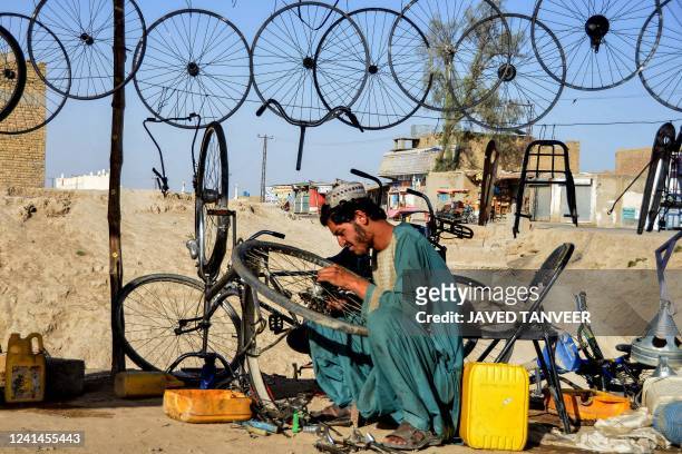 An Afghan man works at a bicycle repair shop in the Zhari district in Kandahar on June 22, 2022.