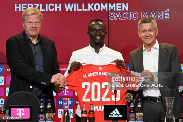 Bayern Munich's Senegalese new forward Sadio Mane with his jersey poses next to Bayern Munich CEO Oliver Kahn and President Herbert Hainer during a...