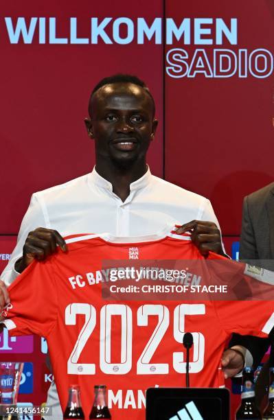 Bayern Munich's Senegalese new forward Sadio Mane poses with his jersey during a press conference after he signed a three-year deal with German first...