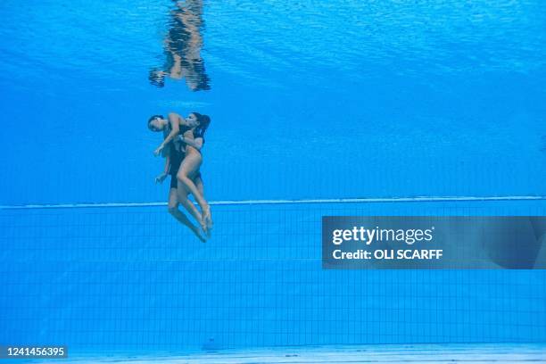 S Anita Alvarez is recovered from the bottom of the pool by USA's coach Andrea Fuentes after an incident, during the women's solo free artistic...