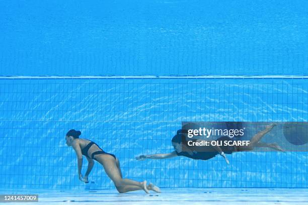 S coach Andrea Fuentes swims to recover USA's Anita Alvarez , from the bottom of the pool during an incident in the women's solo free artistic...