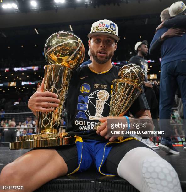 Stephen Curry of the Golden State Warriors poses with the Larry OBrien Trophy and the Bill Russell NBA Finals MVP Award after Game Six of the 2022...