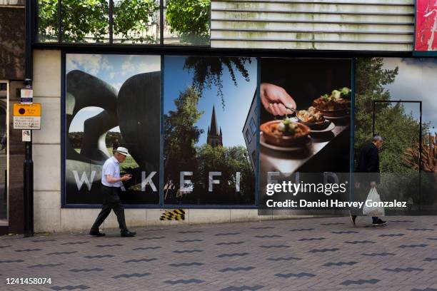 Shoppers pass by a wall mounted tourism advertisement on the city centre's high street as the cost of living crisis in the country worsens with the...