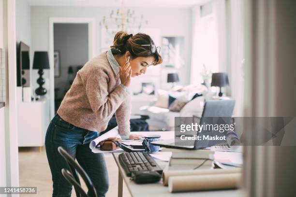 woman standing by table working from home - self employed photos et images de collection