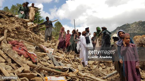 People help for the search and rescue operations on debris of a building after a magnitude 7.0 earthquake shook Afghanistan at noon and killed at...