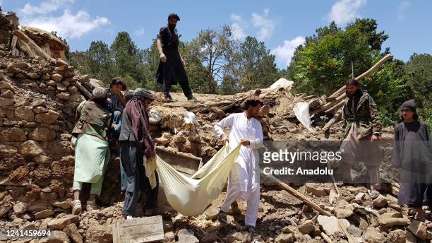 People carry a dead body removed from debris of a building after a magnitude 7.0 earthquake shook Afghanistan at noon and killed at least 29 people,...