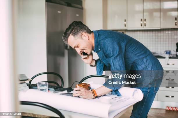 happy casual businessman talking on the phone at home - industrial designer stockfoto's en -beelden