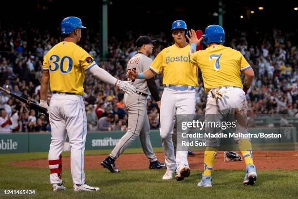 Bobby Dalbec of the Boston Red Sox reacts with Rob Refsnyder of the Boston Red Sox and Christian Vázquez of the Boston Red Sox after scoring during...