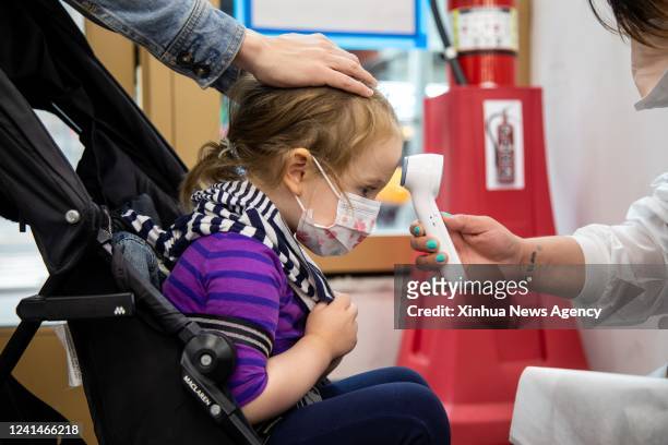 Girl has her temperature measured at a COVID-19 vaccination site in Times Square, New York, the United States, on June 22, 2022. The United States...