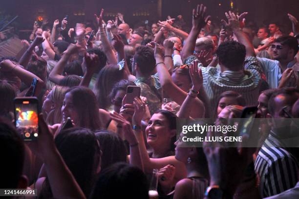 People party at the Pacha Ibiza nightclub in Ibiza, on June 16, 2022. - After being closed for two years because of the Covid-19 pandemic, the...