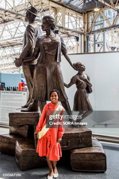 School girl stands in front of the monument, depicting a man, woman and child standing on top of suitcases, which was revealed to mark the annual...