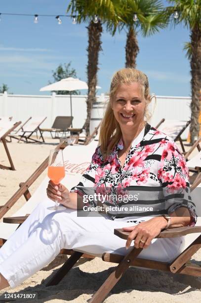 June 2022, North Rhine-Westphalia, Euskirchen: Presenter Maxi Biewer sits in a deck chair at the opening of the Beach Club at Therme Euskirchen. The...