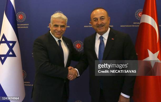 Turkish Foreign Minister Mevlut Cavusoglu shakes hands with Israeli Foreign Minister Yair Lapid ahead of a meeting in Ankara on June 23, 2022.