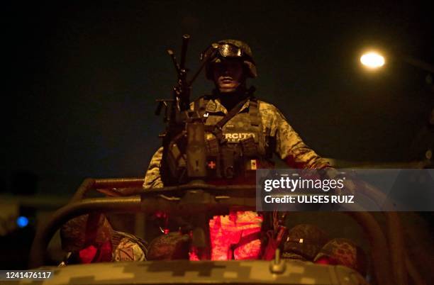 Members of the Mexican Army stand guard at the site where four police officers and eight alleged members of the organized crime were killed, and six...