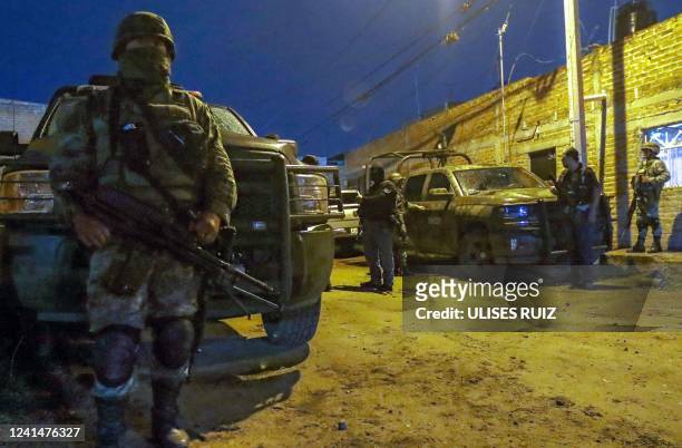 Members of the Mexican Army stand guard at the site where four police officers and eight alleged members of the organized crime were killed, and six...