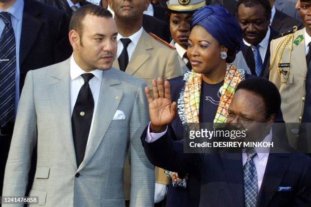 King Mohammed VI of Morocco is flanked by Gabonese First Lady Edith Lucie Bongo and Gabonese President Omar Bongo upon his arrival at Leon Mba...