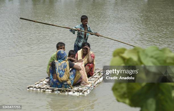 Flood affected people moves on a raft in a flood affected area, at a village on June 23, 2022 in Barpeta, India. Assam flood situation deteriorates...