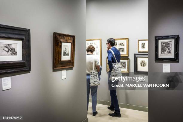 Visitors look on to art pieces on the wall during the final preparations for the TEFAF art and antiques fair for its first edition since the COVID-19...