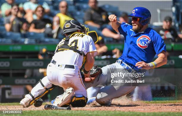 Patrick Wisdom of the Chicago Cubs is tagged out at home plate by Tyler Heineman of the Pittsburgh Pirates in the tenth inning during the game at PNC...