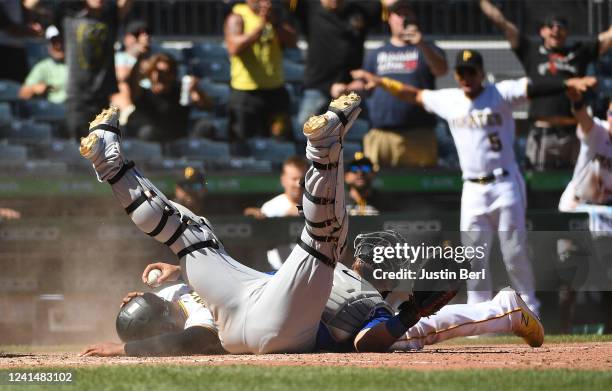 Ke'Bryan Hayes of the Pittsburgh Pirates collides with Willson Contreras of the Chicago Cubs at home plate as he scores the winning run on a walk-off...