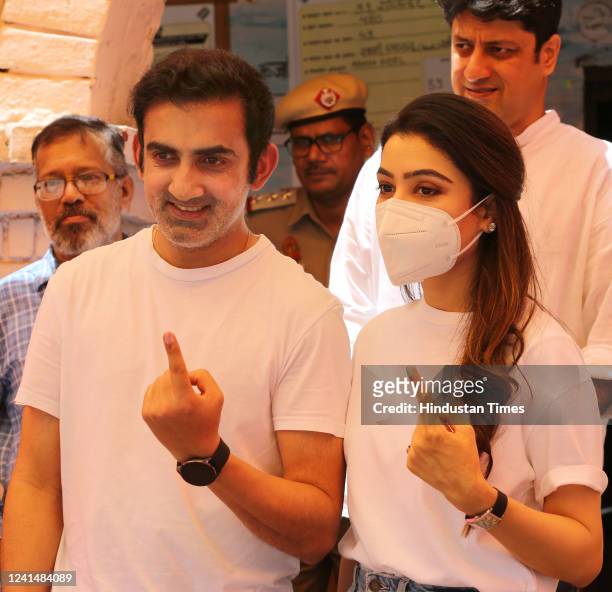 Gautam Gambhir, Member of Parliament and his wife Natasha Jain, show their inked fingers after casting their votes for the Rajinder Nagar bypoll...