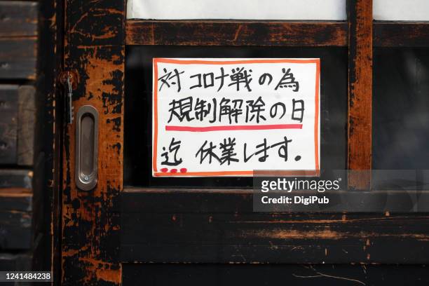 handwriting self-restraint massage on the door of a japanese restaurant - state of emergency stock pictures, royalty-free photos & images