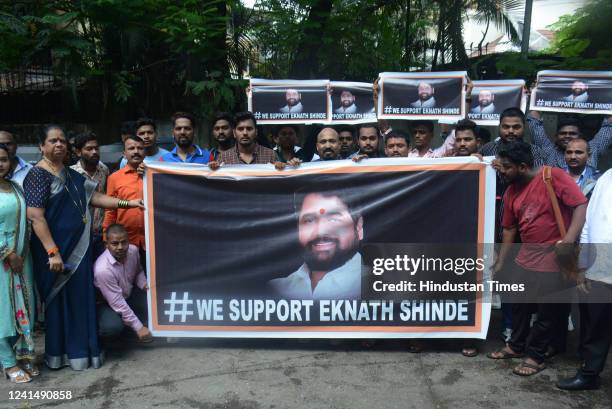 Few supporters of Maharashtra Minister and Shiv Sena leader Eknath Shinde hold a banner expressing their solidarity and support to him outside his...