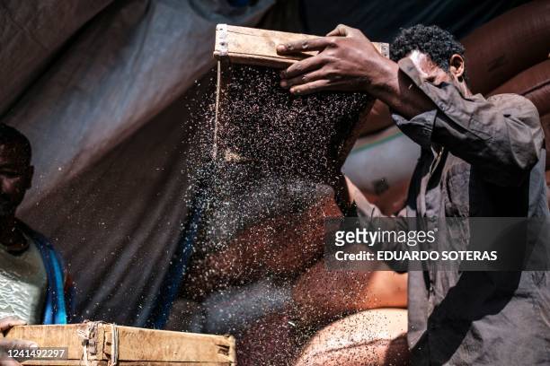 Men thresh grain in a market in the city of Addis Ababa, Ethiopia, on June 23, 2022.In a context of an increasing inflation, and still submerged in...