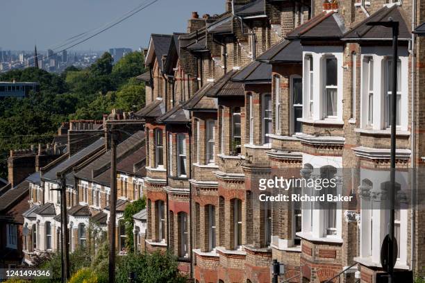 South London residential street with homes leading downhill towards the city in the distance, at Crystal Palace in south London, on 22nd June 2022,...