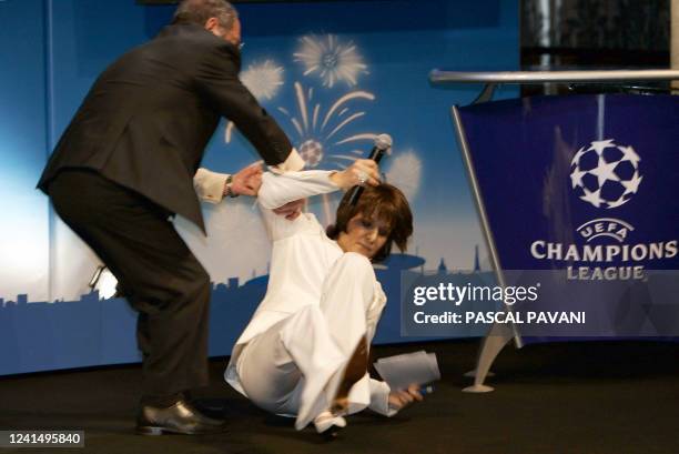 French TV host Carole Rousseau faints 10 March 2006 at Paris City hall during the draw of the quarter-finals of the European football Champions...