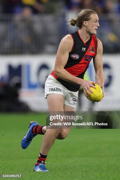 Mason Redman of the Bombers runs with the ball during the 2022 AFL Round 15 match between the West Coast Eagles and the Essendon Bombers at Optus...