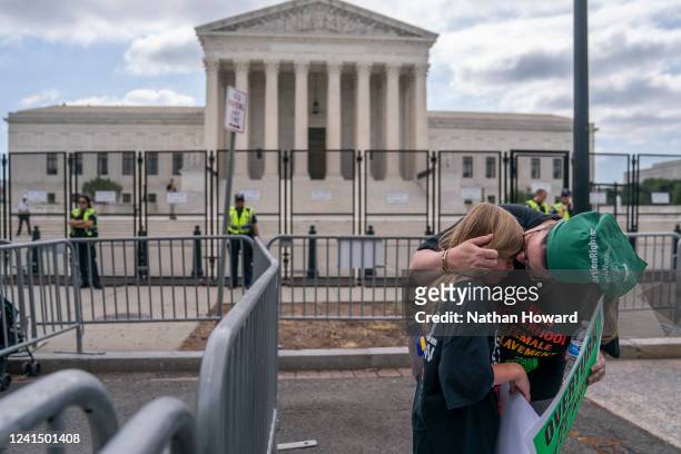 An abortion-rights activist comforts her daughter following the 6-3 ruling in Dobbs v. Jackson Women's Health Organization which overturns the...