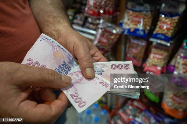 Customer counts out 200 Turkish lira banknotes for a purchase in Istanbul, Turkey, on Friday, June 24, 2022. Tourism arrivals in May surged 308%...