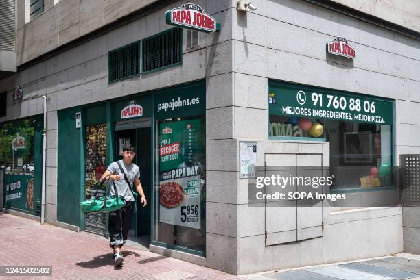 Courier worker is seen delivering an order as he leaves the American pizza restaurant franchise Papa John's Pizza in Spain.