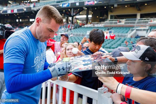 Freddie Freeman of the Los Angeles Dodgers signs autographs for fans prior to the game against the Atlanta Braves at Truist Park on June 24, 2022 in...