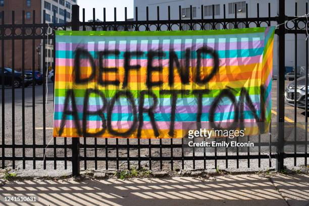 Flag spray painted with Defend Abortion hangs on a fence outside where abortion rights activists gather to protest the Supreme Court's decision in...