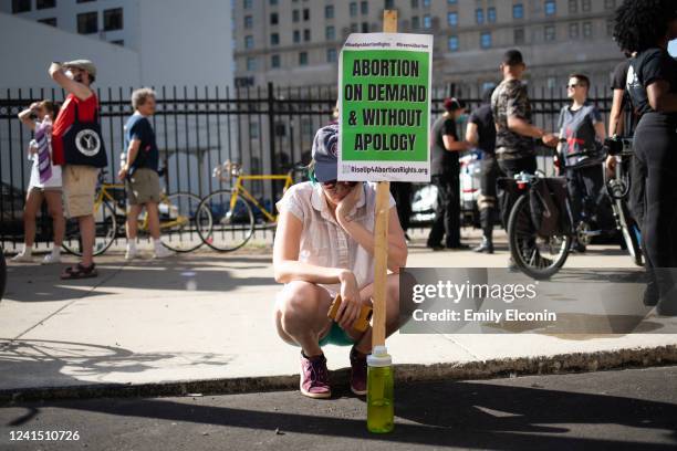An abortion rights demonstrator bows their head as people protest the Supreme Court's decision in the Dobbs v Jackson Women's Health case on June 24,...