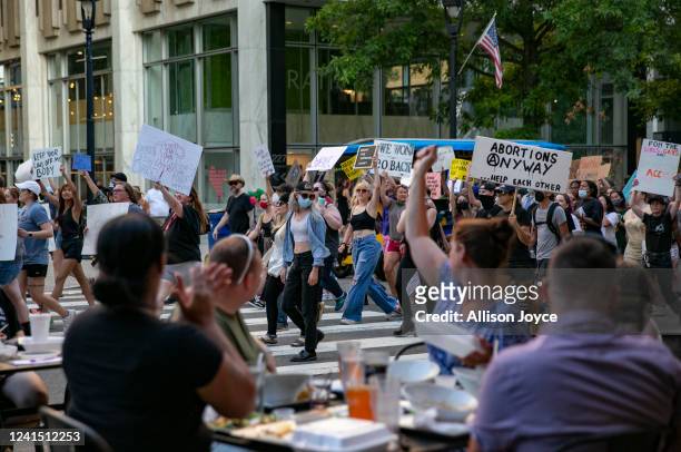 Protest against the Supreme Court's decision in the Dobbs v Jackson Women's Health case passes by a restaurant on June 24, 2022 in Raleigh, North...