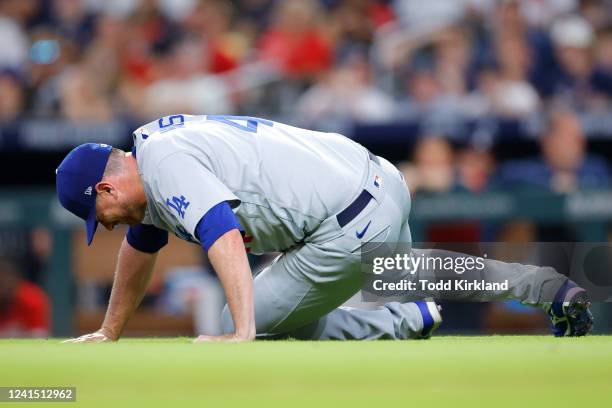 Daniel Hudson of the Los Angeles Dodgers goes down with an injury during the eighth inning against the Atlanta Braves at Truist Park on June 24, 2022...