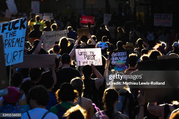 People hold up signs as they march in protest of the Supreme Court's decision to overturn Roe v. Wade on June 24, 2022 in Portland, Oregon. The...