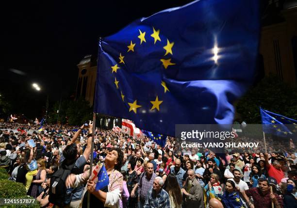 People wave EU flags during a rally gathering tens of thousands of attendees in support of Georgia's candidacy for European Union membership, on June...