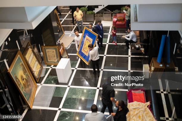 Two employees carrying back a framed Calligraphy to the backstage during the 7th Art of the Islamic and Iranian Worlds Auction, held by Melli Auction...