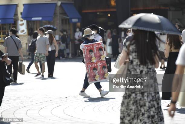 Supporter is seen carrying a poster of Mizuho Fukushima, head of the Social Democratic Party, opposition party, during a street meeting on June 25,...
